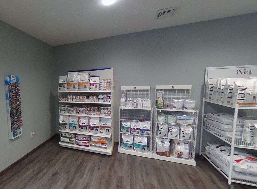 Shelves filled with various pet medications and supplies in a retail space.